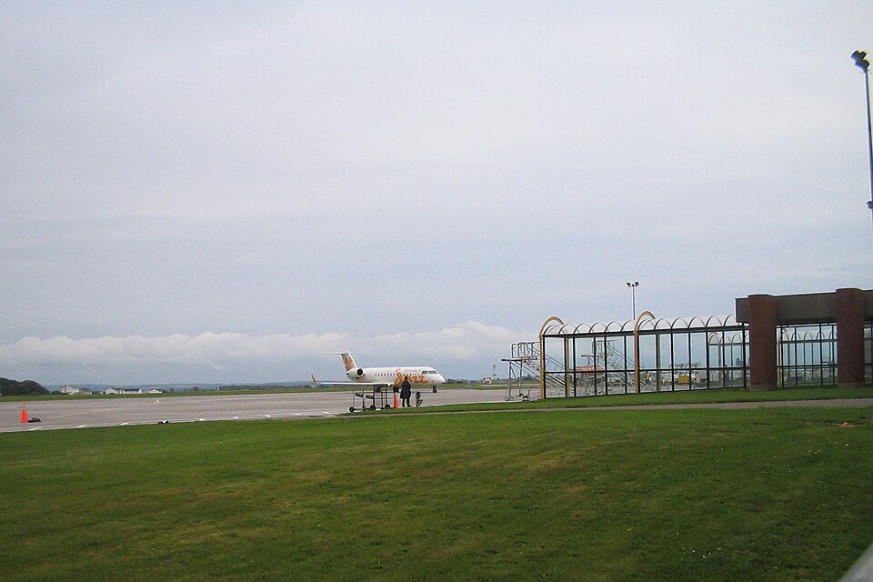 A large group of pilgrims gathering at an airport arrivals area
