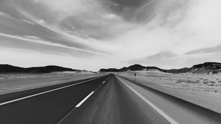 Black and white view of an empty desert highway in Tabuk, Saudi Arabia