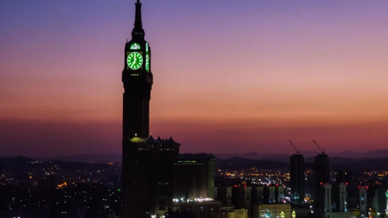 Makkah clock tower silhouetted against a dusk sky