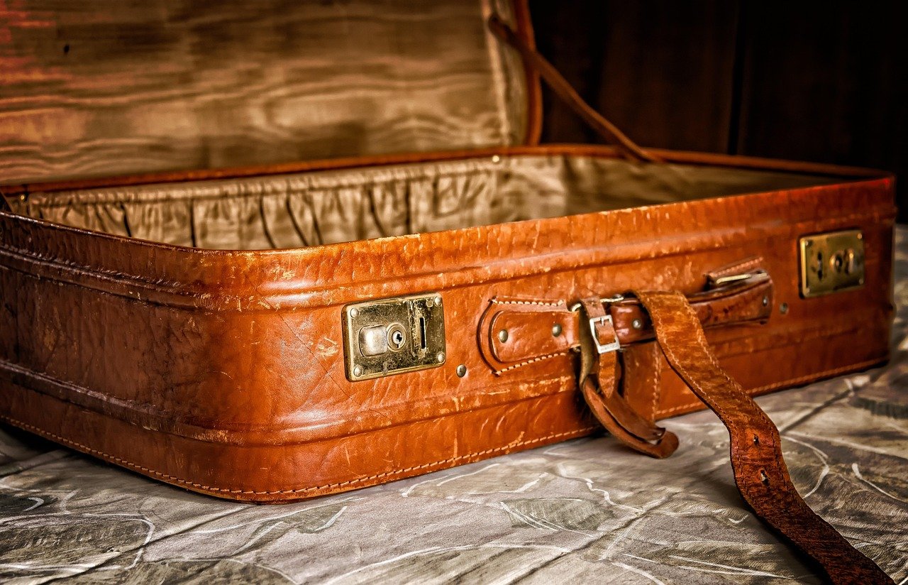 An open suitcase being packed for travel, representing preparation before a first Hajj trip