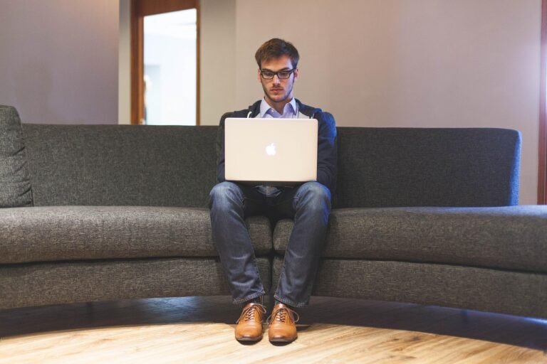 Business traveller working on a laptop while planning an Umrah trip around work commitments