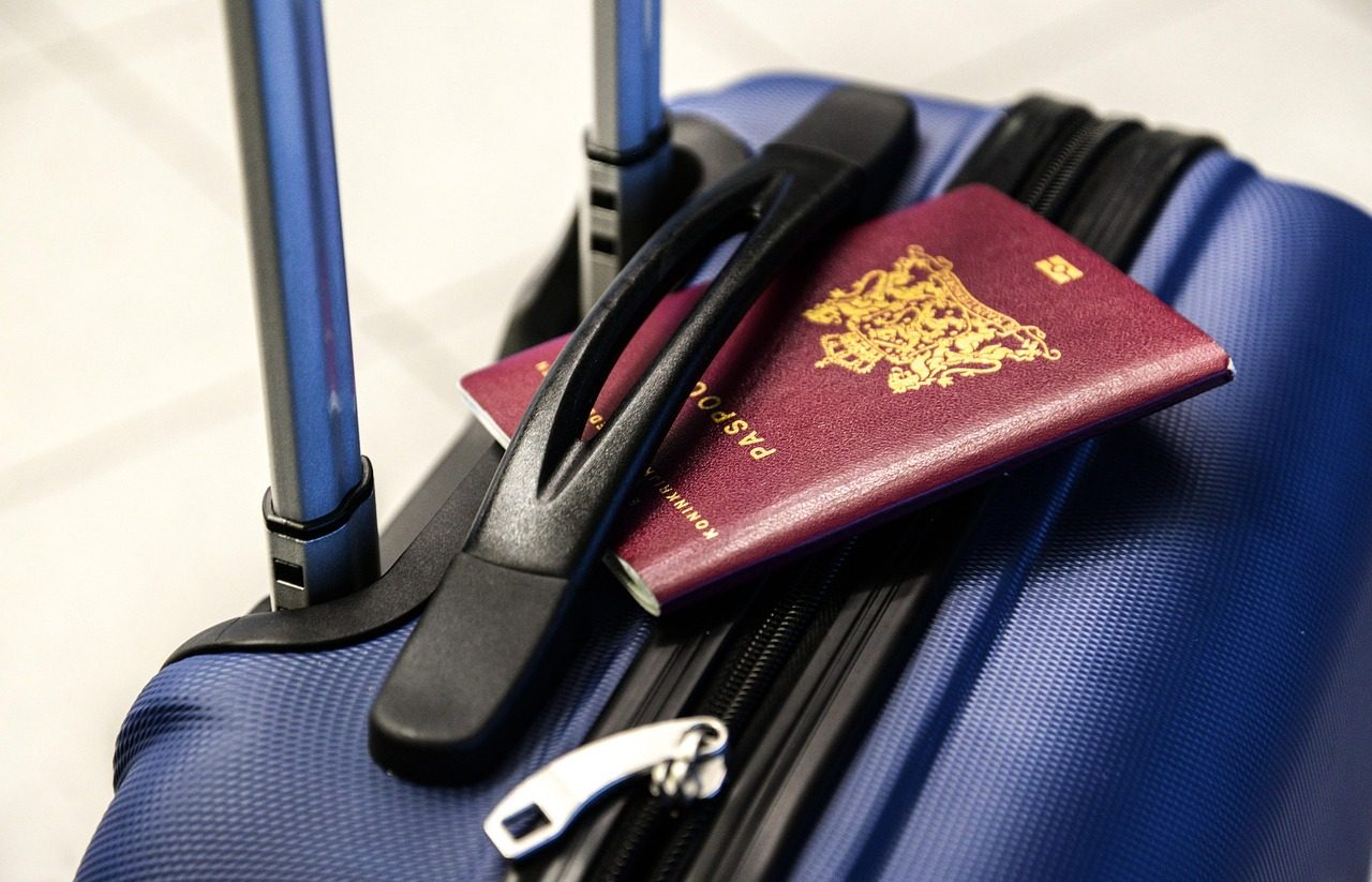 Passport and luggage trolley representing documents to check against a Hajj transport package