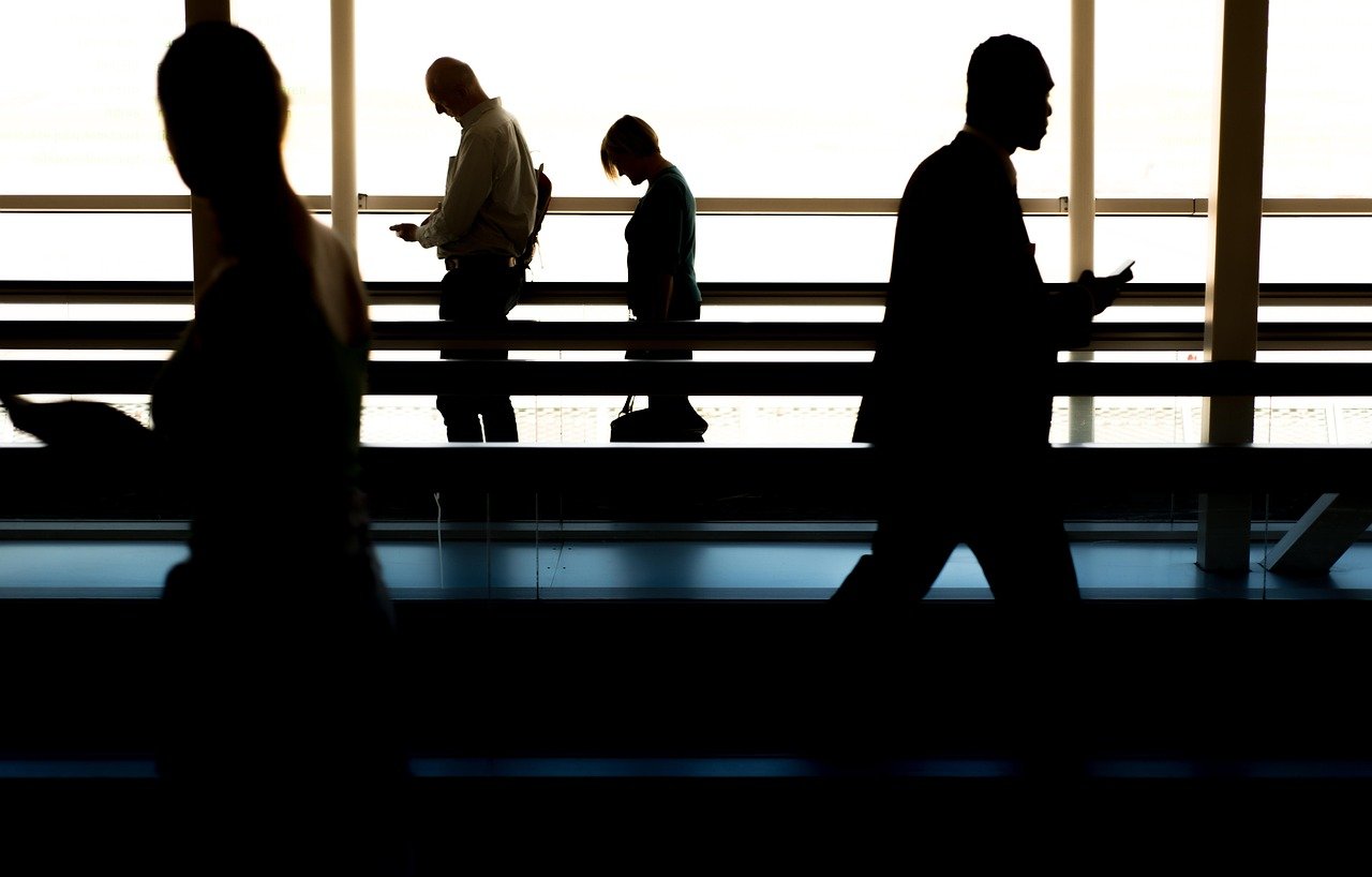 Travellers walking through an airport gate as part of a pilgrim group