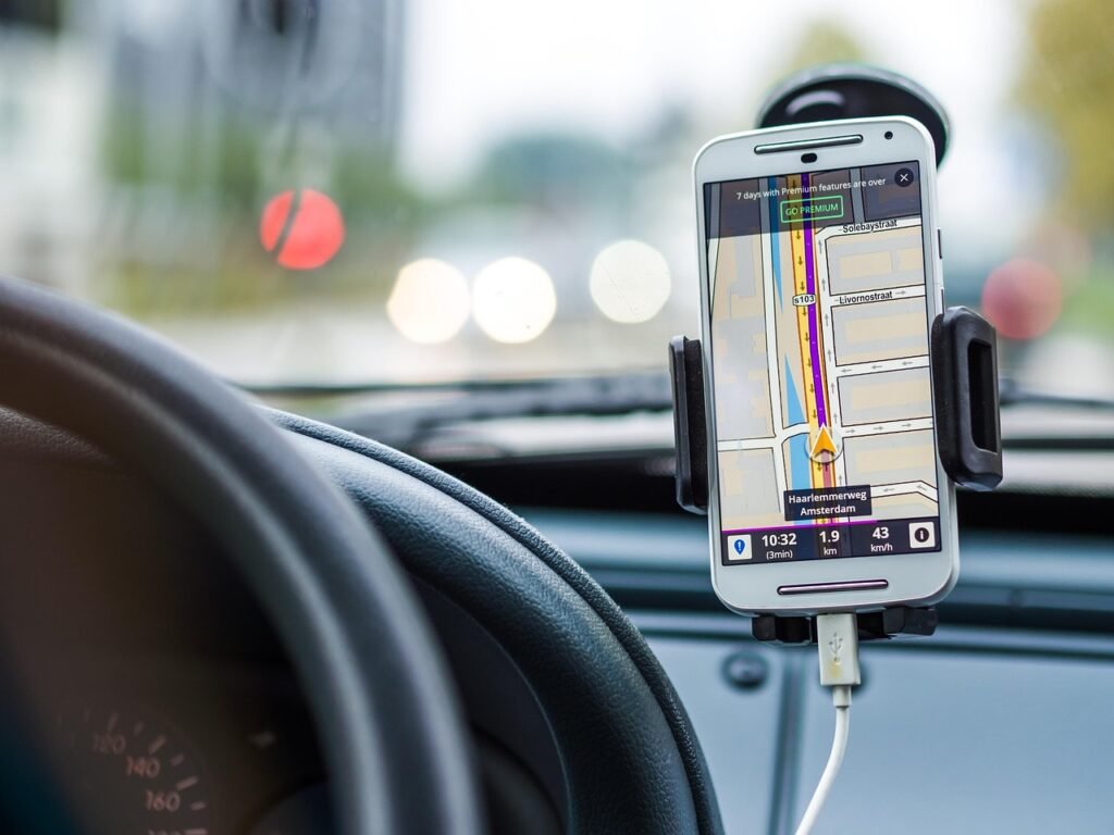 Pilgrim's smartphone charging inside a vehicle during a long road transfer