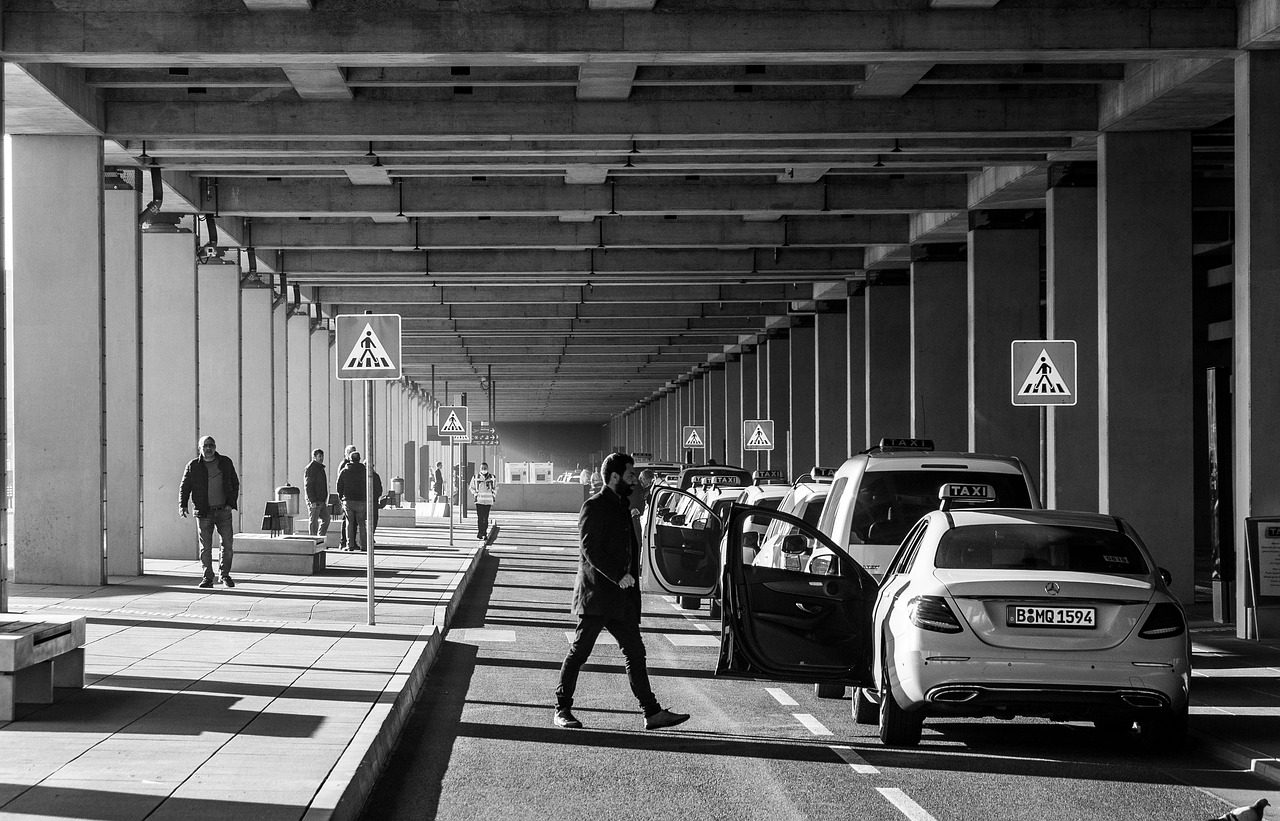 A pilgrim checking a phone for a last-minute transport booking confirmation at the airport