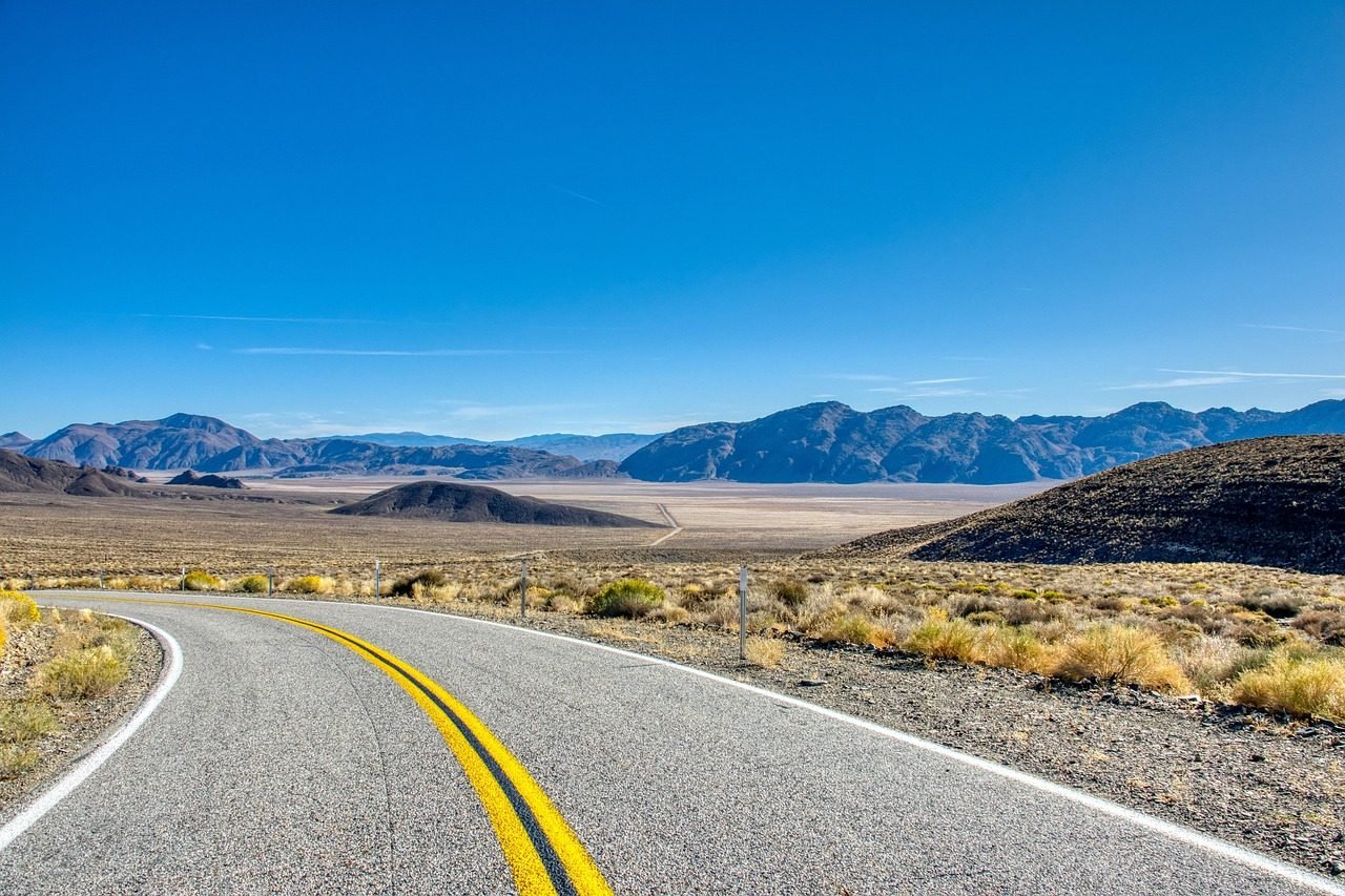 A paved road through desert terrain, typical of the roads travelled between Saudi cities